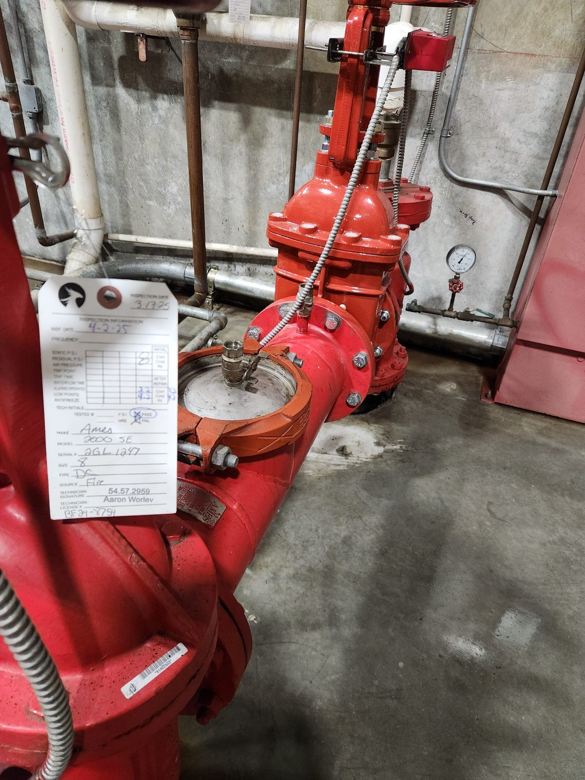 Ames 2000 SE fire-line double-check backflow with a Phoenix Fire & Systems inspection tag